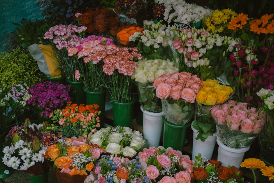 A vibrant display of fresh floral arrangements at Tottenham Florist, featuring a variety of flowers including pink roses, white roses, yellow roses, pink and white carnations, purple and white daisies